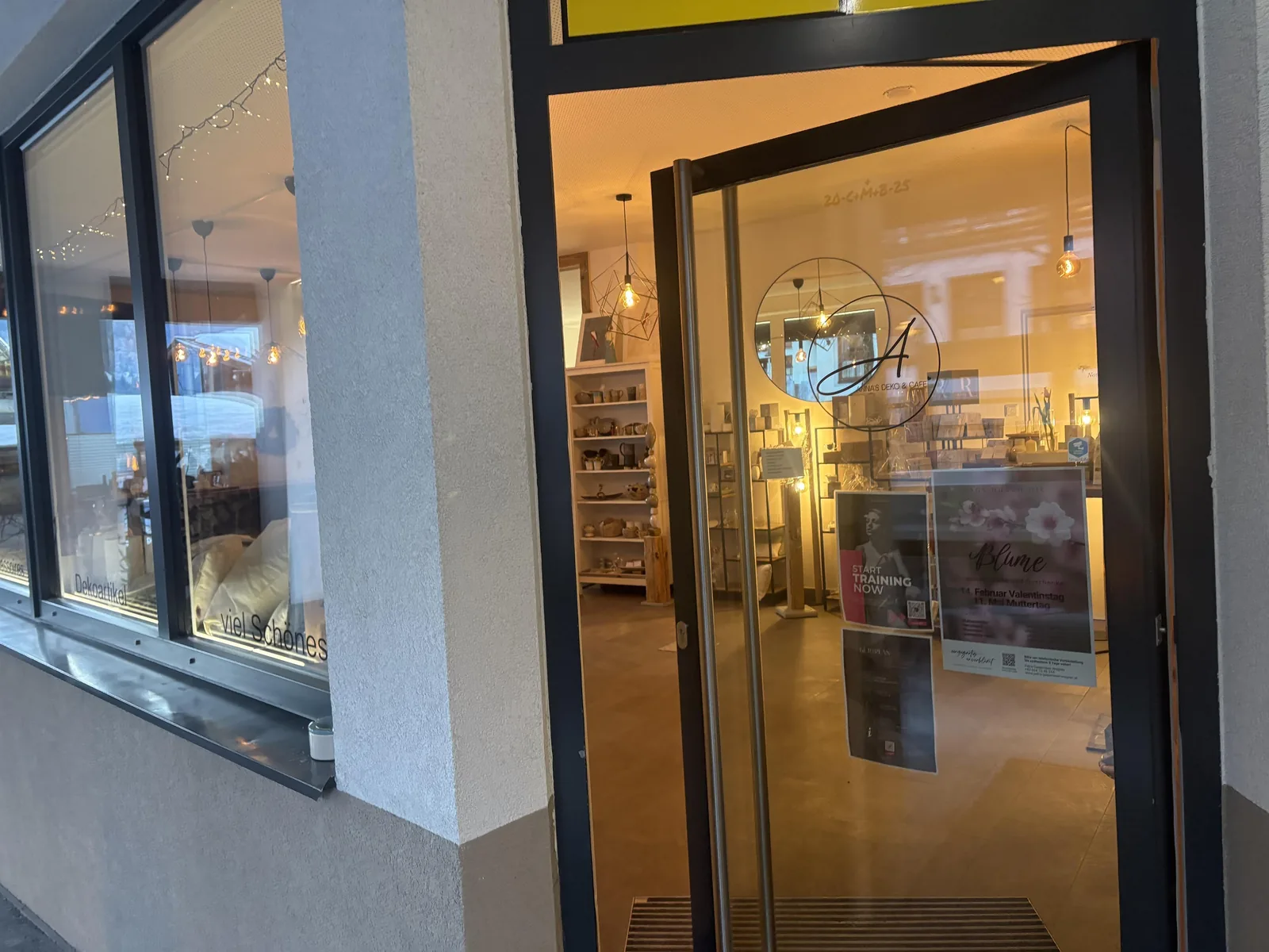 Offene Eingangstür mit Blick in den beleuchteten Verkaufsraum